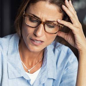 woman with glasses having a headache