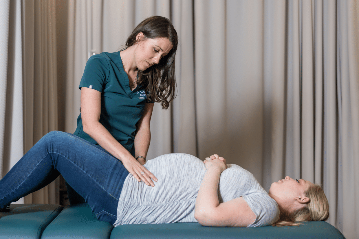 female chiropractor treating a pregnant woman on a drop table