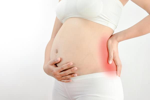 torso shot of pregnant woman patient suffering from prenatal back pain