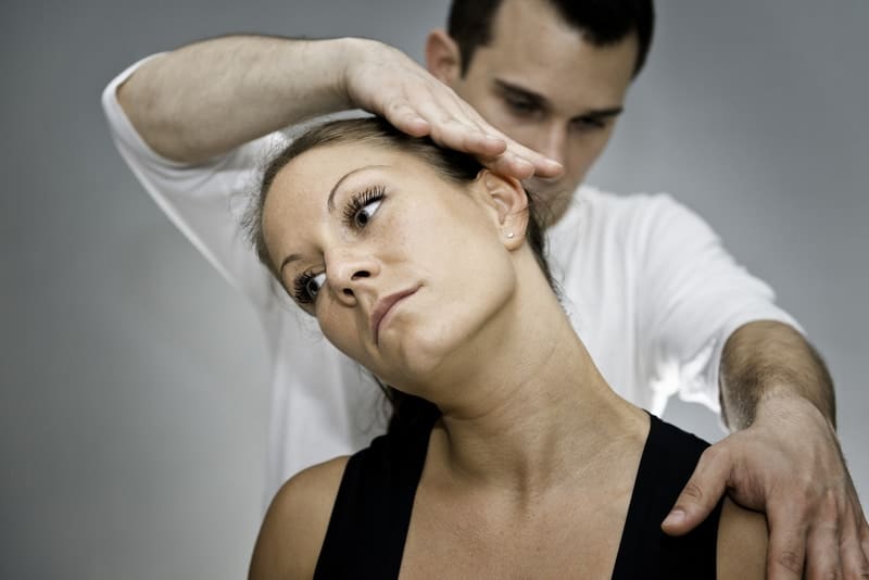 Chiropractor doing treatment to the patient who suffers from whiplash