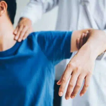cropped image of a chiropractor adjusting a patient's neck and arm