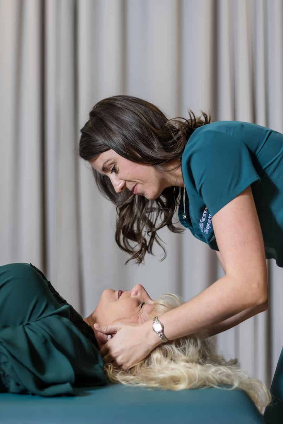 Chiropractor performing a gentle cervical neck adjustment on a patient.