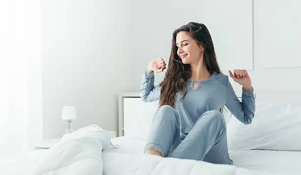 Woman doing some stretching after waking up in her bed at home