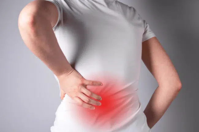 Woman suffering from Muscle Spasms in lower back pain.
