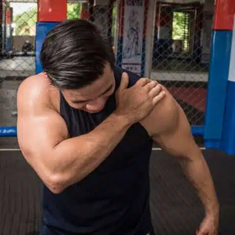 A fit man suffers from Torn cartilage during exercise in the gym.