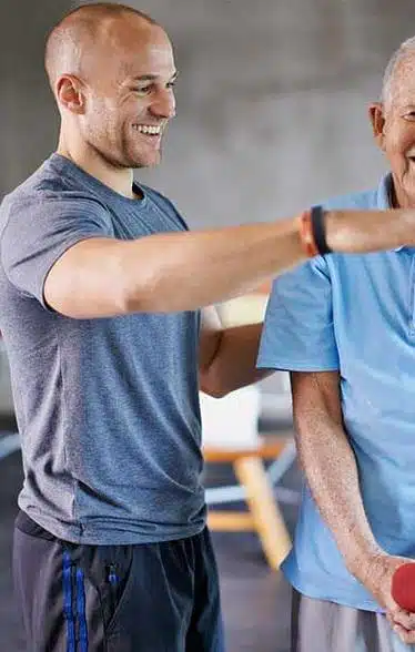 Physiotherapist helping a senior man to under go a physical therapy.