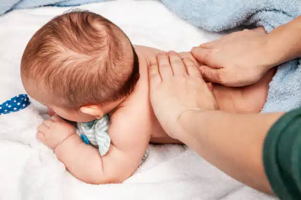 Baby receives a pediatric chiropractic care from a doctor.