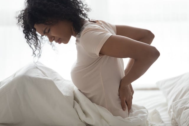 Woman having a difficulty in sleeping cause of back pain