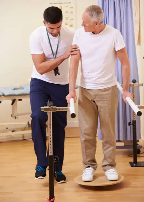 Senior man having some physical therapy session at the chiropractic clinic.