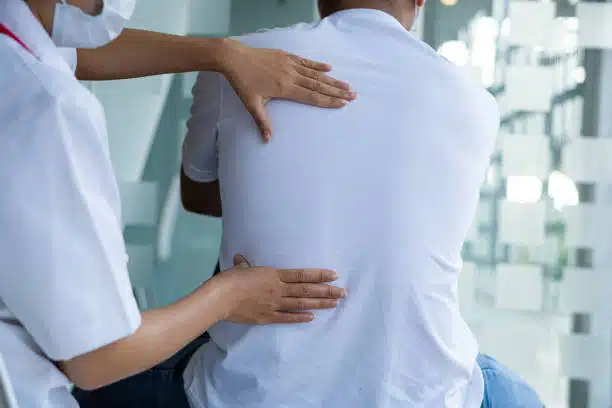 Patient suffers from spine and back problems having a consultation with a chiropractor. 