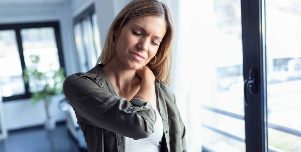 Tired young woman suffers from neck pain.