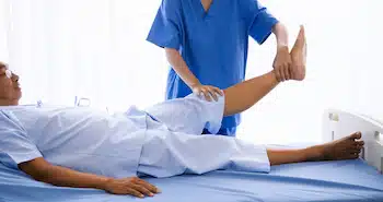 Physical therapist doing physical therapy for adult patient at hospital room after operation