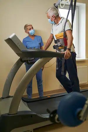 Professional physiotherapist working with patient in rehabilitation center after operation