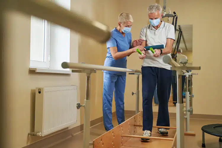 Professional physiotherapist working with patient in rehabilitation center