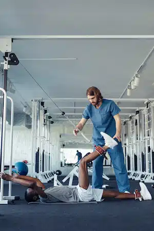 athlete doing rehab exercises with physical therapist after injury for training