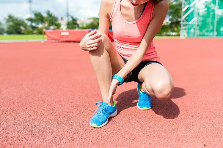 Woman athlete getting injured during tack and field sprint
