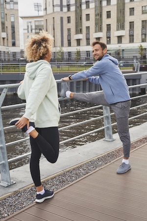 two individuals who is talking while doing a warm-up before exercise.