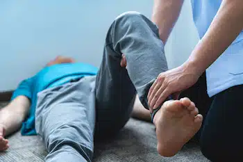 physical therapist doing exercises with patients knee