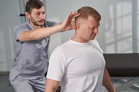 chiropractor examining man's back after acquiring personal injury