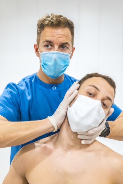 patient with whiplash massaged by chiropractor on the neck