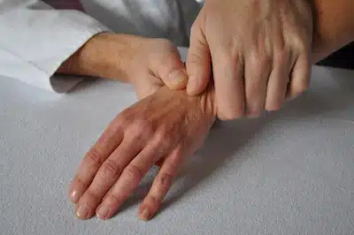 Chiropractic & Physical Rehabilitation  for wrist pain | Chiropractor massaging patients wrist
