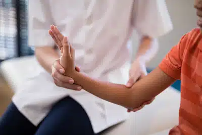 Core Health Spine and Rehabilitation | chiropractor assessing patient's wrist for rehabilitaion