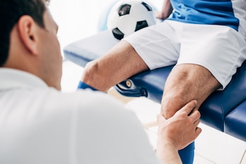 Physiotherapist massaging a leg of a sports player