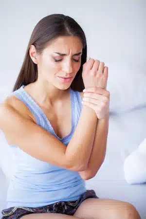 woman with Carpal tunnel syndrome holding her wrist in pain