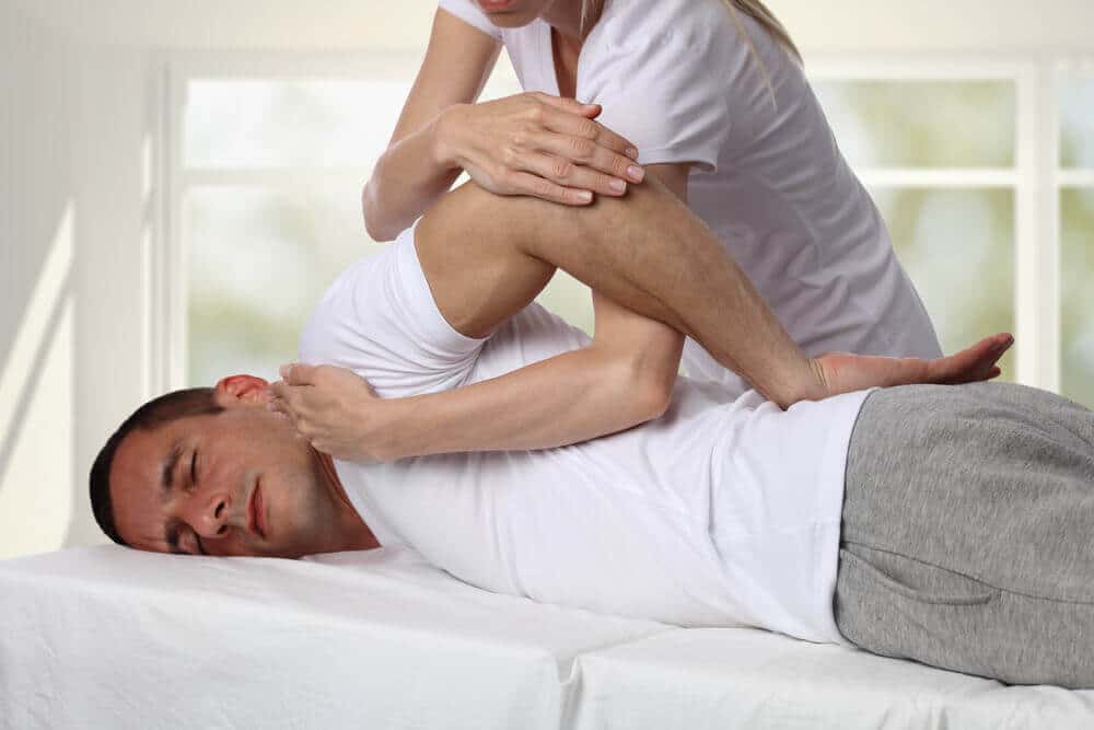 A man receiving chiropractic care lies on a treatment table