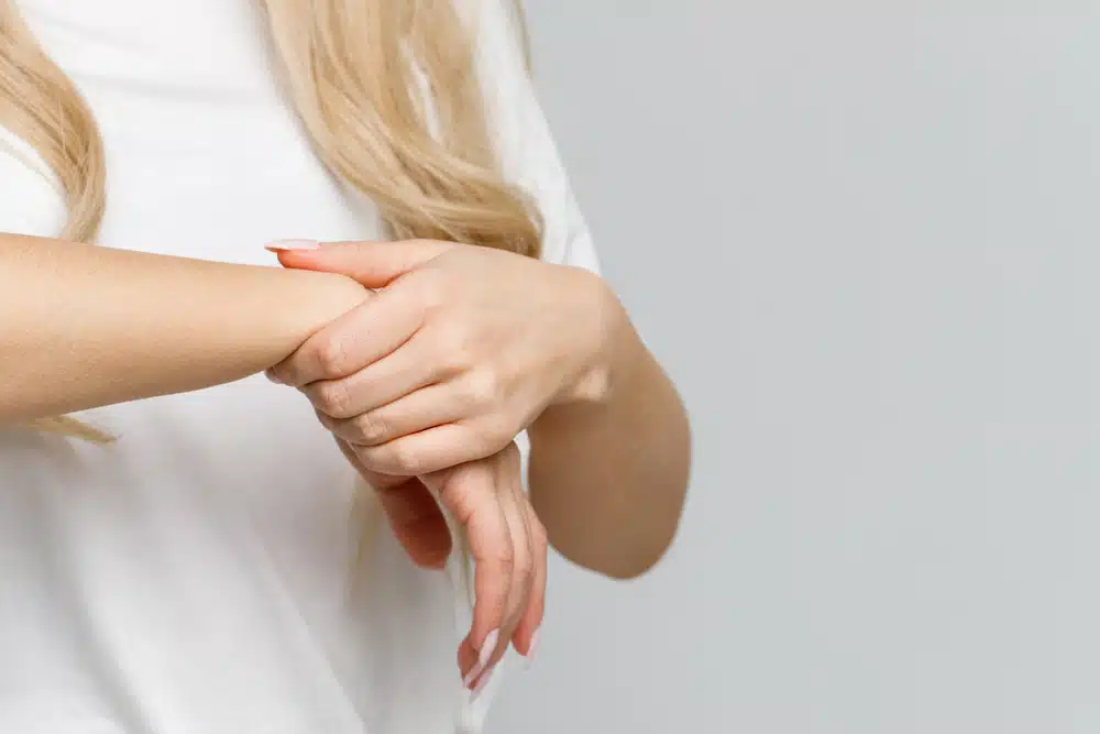 woman arms holding her painful wrist carpal tunnel