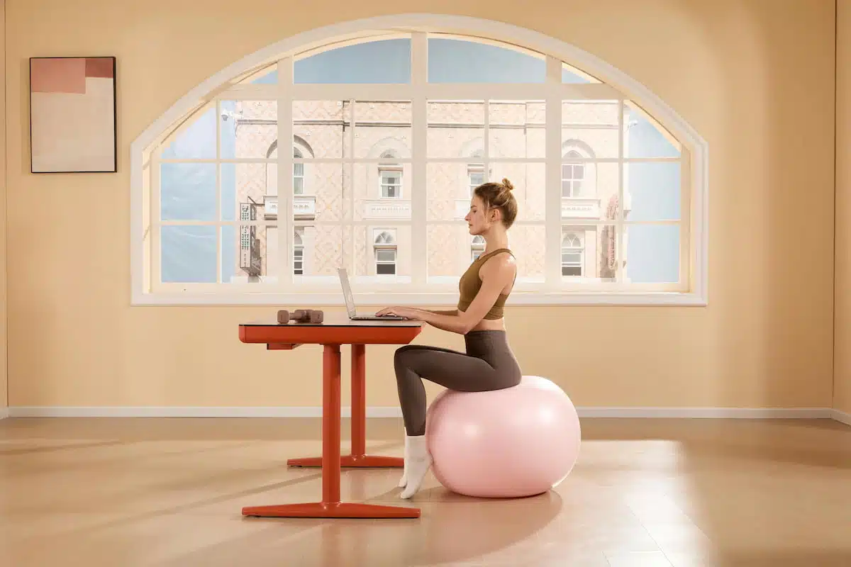 Woman Using Laptop on Exercise Ball at Home