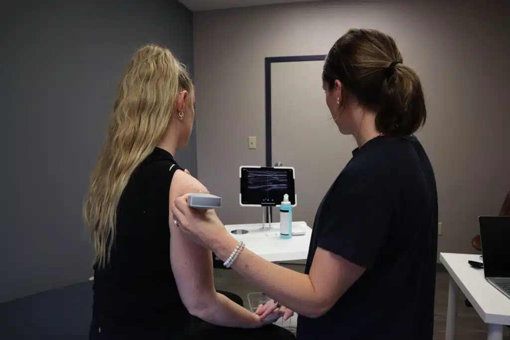 Doctor using diagnostic ultrasound to evaluate shoulder injury.